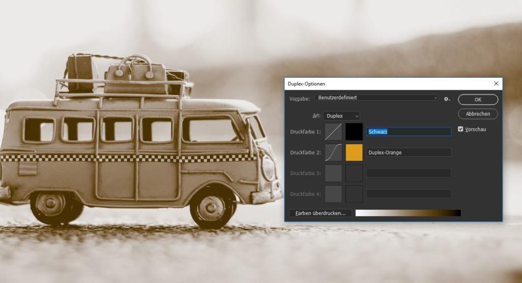 Das sepiafarbene Bild eines Vintage-Spielzeug-Vans mit Gepäck auf dem Dach weckt Nostalgie. Darüber befindet sich eine elegante Photoshop-Oberfläche mit Duoton-Einstellungen in Schwarz und Orange, um Ihre Retro-Kreation zu perfektionieren.