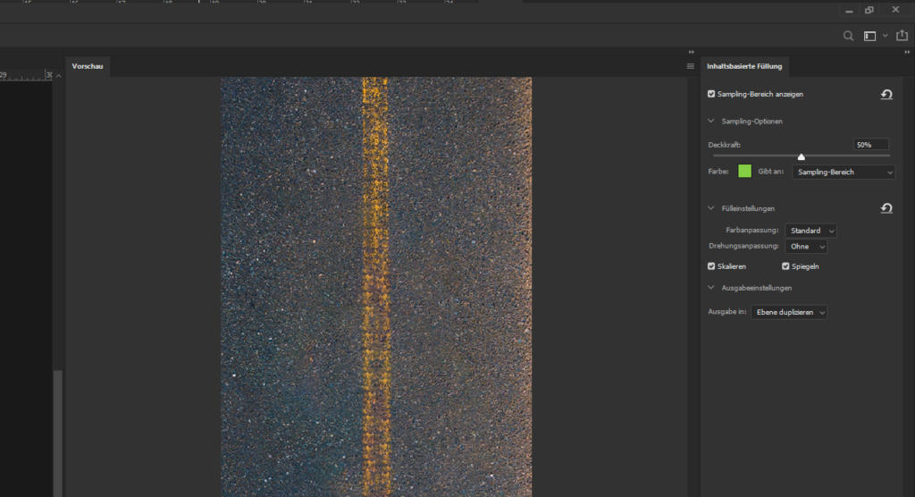 Auf einem Computerbildschirm wird die Oberfläche einer Bildbearbeitungssoftware angezeigt, die an Photoshop erinnert. Das Hauptbild zeigt eine strukturierte Asphaltstraße mit einer durchgezogenen gelben Linie. Bearbeitungsoptionen wie „Inhaltsbasiert füllen“ und Farbeinstellungen sind auf der rechten Seite gut sichtbar.
