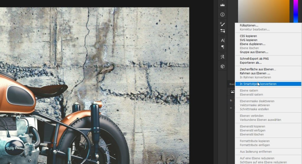 Vor einer verwitterten Betonwand ist ein Oldtimer-Motorrad teilweise zu sehen. Die Photoshop-Oberfläche mit der Ebenenleiste und Optionen wie „In Smartobjekt konvertieren“ ist geöffnet und lädt zur Verwendung kreativer Photoshop-Filter zur Bildverbesserung ein.