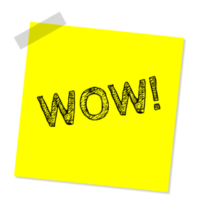 Ein leuchtend gelber Haftnotizzettel mit dem Wort „WOW!“ in fetten, schwarzen, strukturierten Buchstaben dient als auffälliges Element im Eventmarketing. Der Zettel wirft einen leichten Schatten und verleiht so dem weißen Hintergrund ein dreidimensionales Flair.