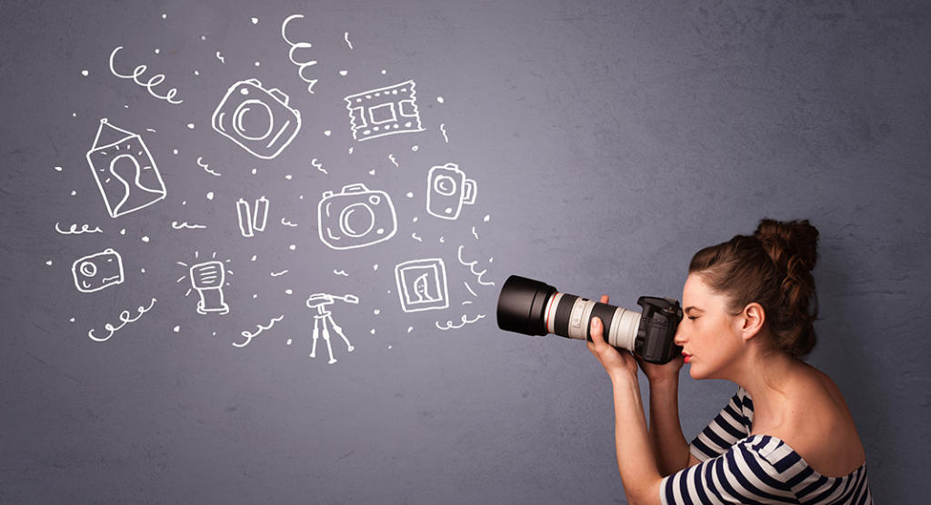 Eine Frau im gestreiften Hemd blickt durch eine Kamera mit großem Objektiv und fängt Momente ein, die an Eventmarketing-Magie erinnern. Weiße Kritzeleien von Kameras, Objektiven und Fotos schweben auf dem grauen Hintergrund und unterstreichen ihre Leidenschaft für visuelles Geschichtenerzählen.