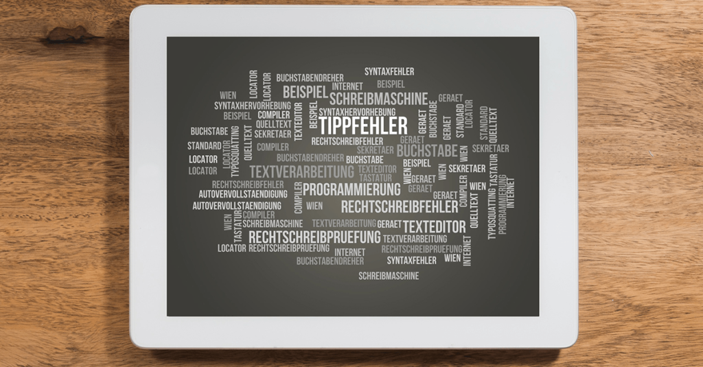 Auf einer Holzoberfläche befindet sich eine Tafel, auf der eine Wortwolke in deutscher Sprache angezeigt wird. Darin sind Wörter wie „Tippfehler“, „Textverarbeitung“ und „Programmierung“ hervorgehoben, umgeben von verwandten Begriffen, wobei „Textanalyse“ in verschiedenen Größen und Ausrichtungen hervorgehoben wird.
