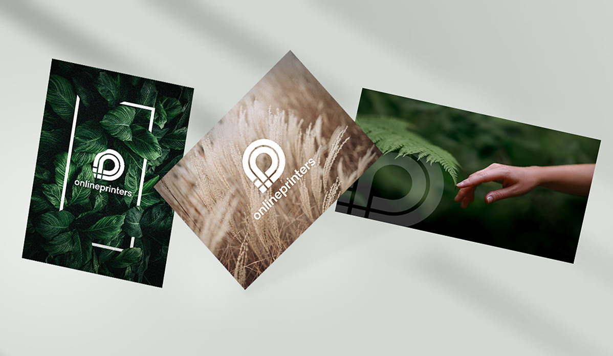 Drei übereinanderliegende Visitenkarten, die an die Postkartengeschichte erinnern, zeigen organische Designs: Eine ist mit grünen Blättern verziert, eine andere mit Weizen und eine dritte zeigt eine Hand, die ein Blatt berührt. Jede Karte präsentiert stolz das „Onlineprinters“-Logo vor einem hellen, gedeckten Hintergrund.